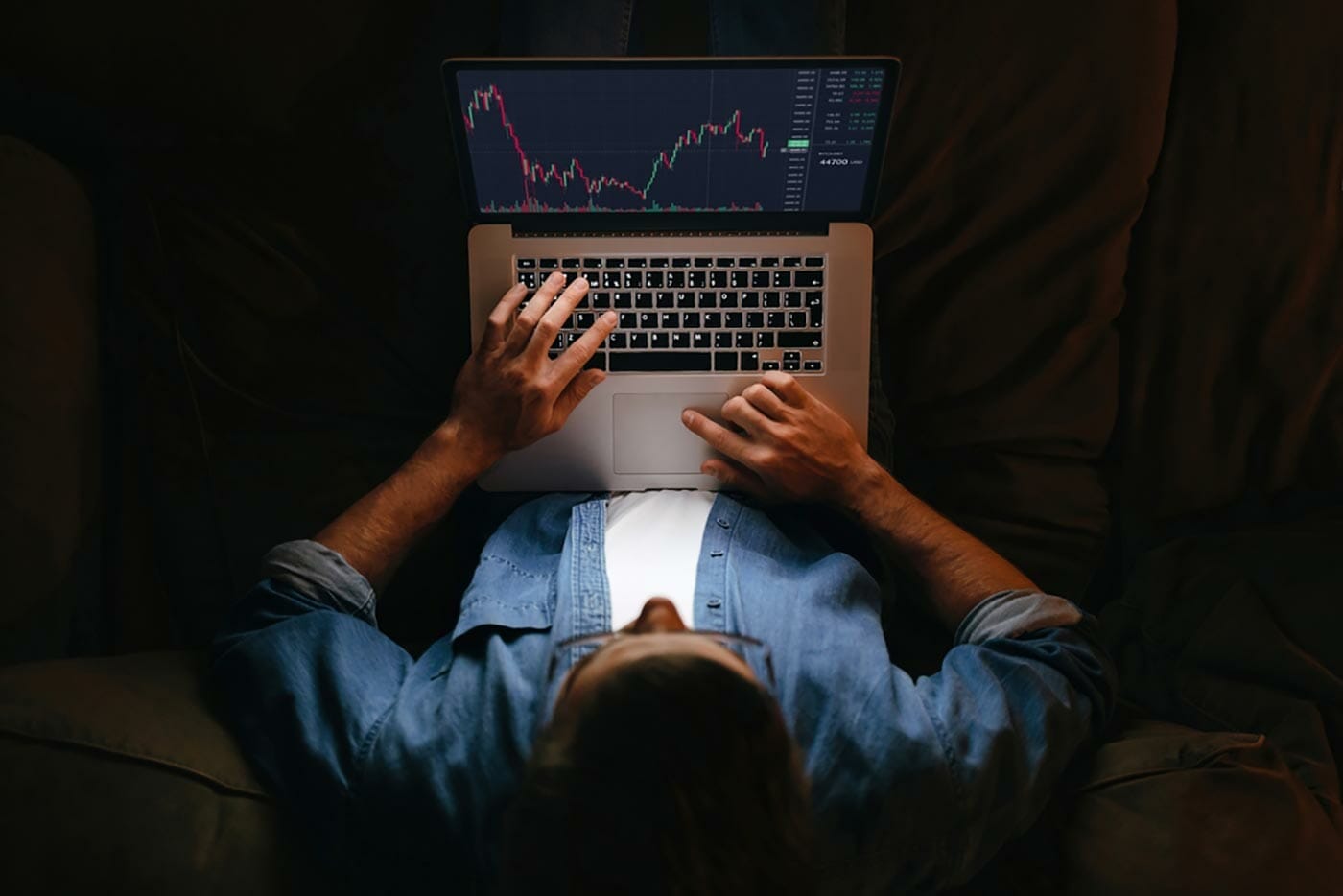 A funded trader reviews recent trading data on their laptop computer.