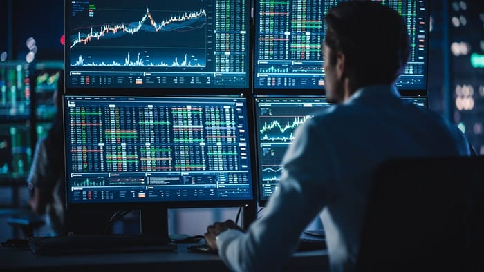 Successful young day trader studing price movement charts on computer
