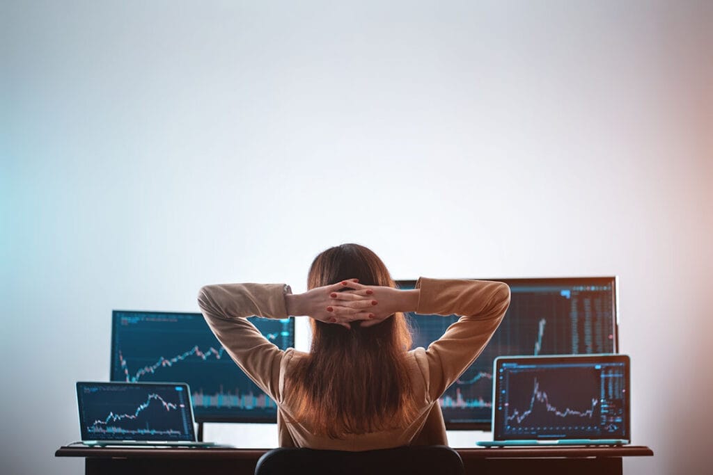 Day trader sits back and watches multiple monitors to keep tabs on market conditions