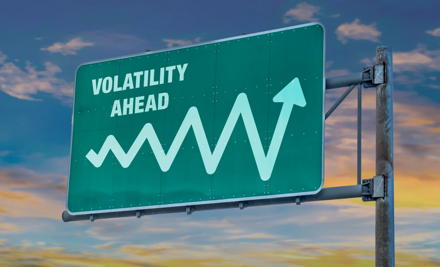 A highway sign reading “Volatility Ahead” and including a sample line graph moving up and down quickly.